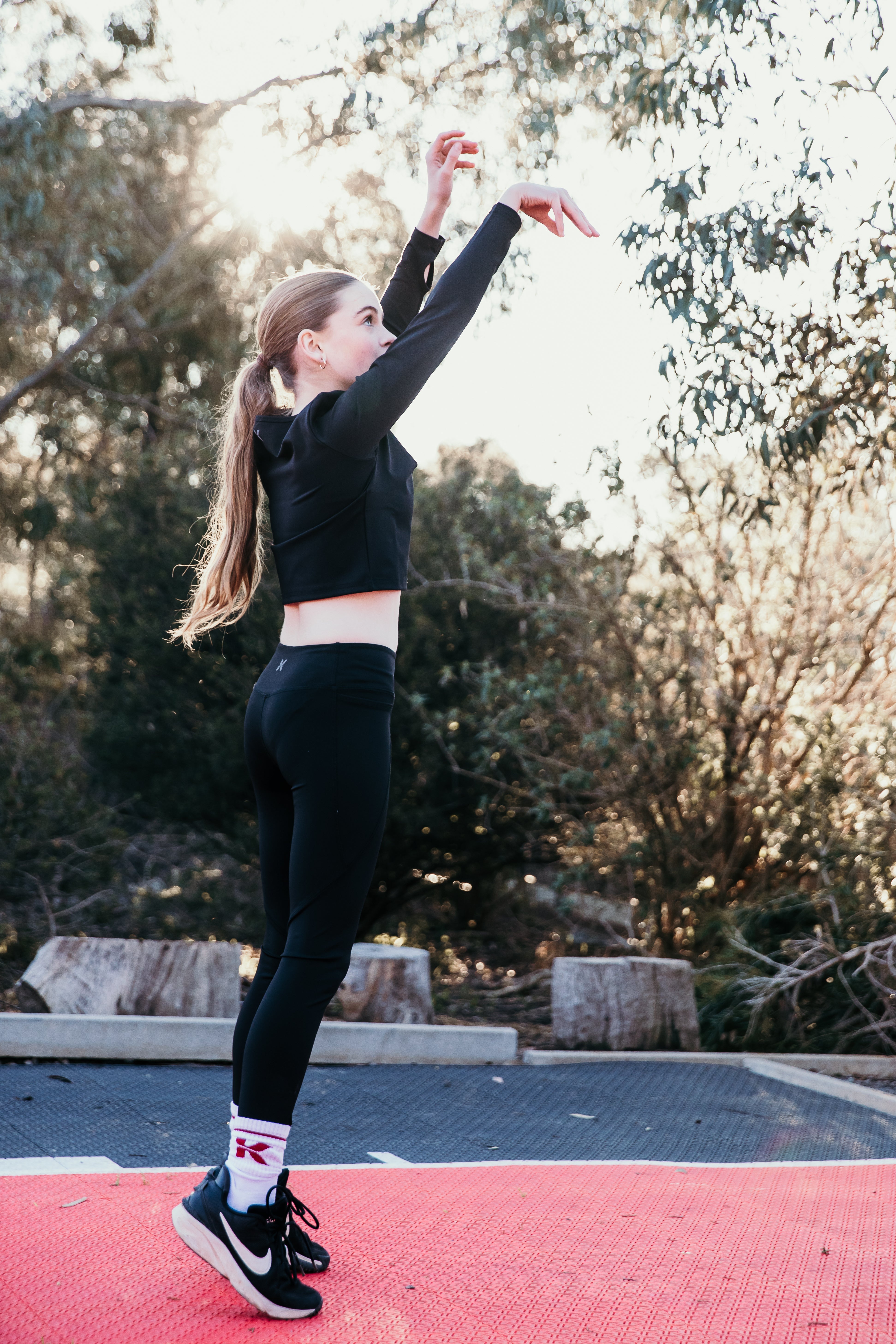 Tween girl stretching outdoors in the Athletik Tween Starter Set